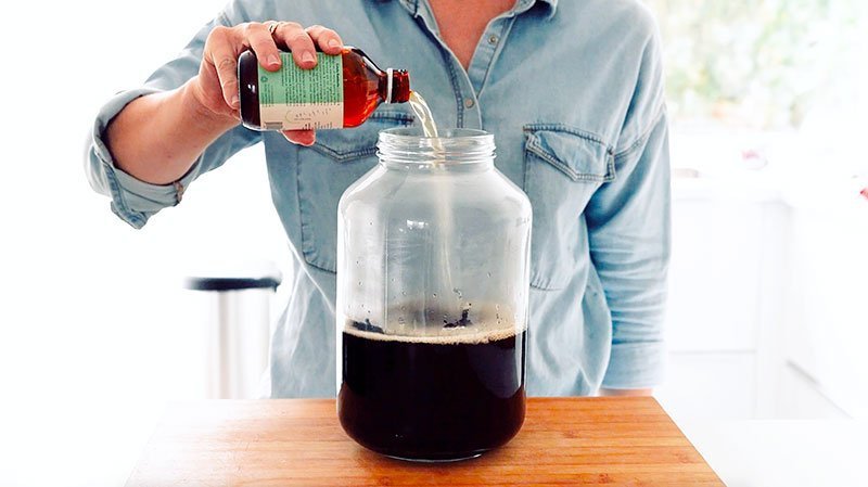 Pouring starter kombucha into jar