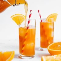 Pouring vanilla orange kombucha into a glass