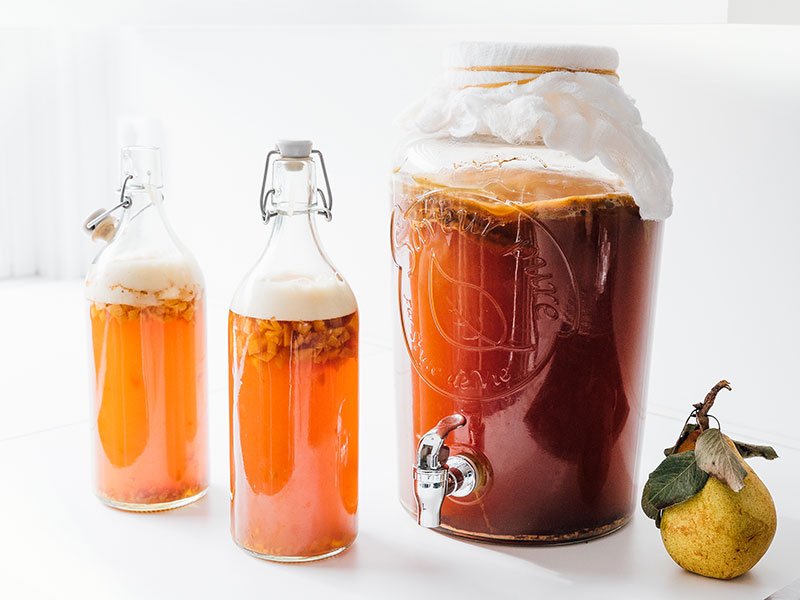 Pear kombucha in bottles with white background