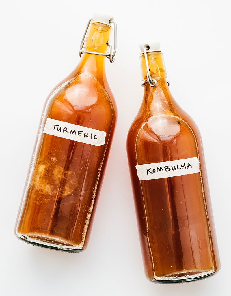 Turmeric kombucha in bottles on white background