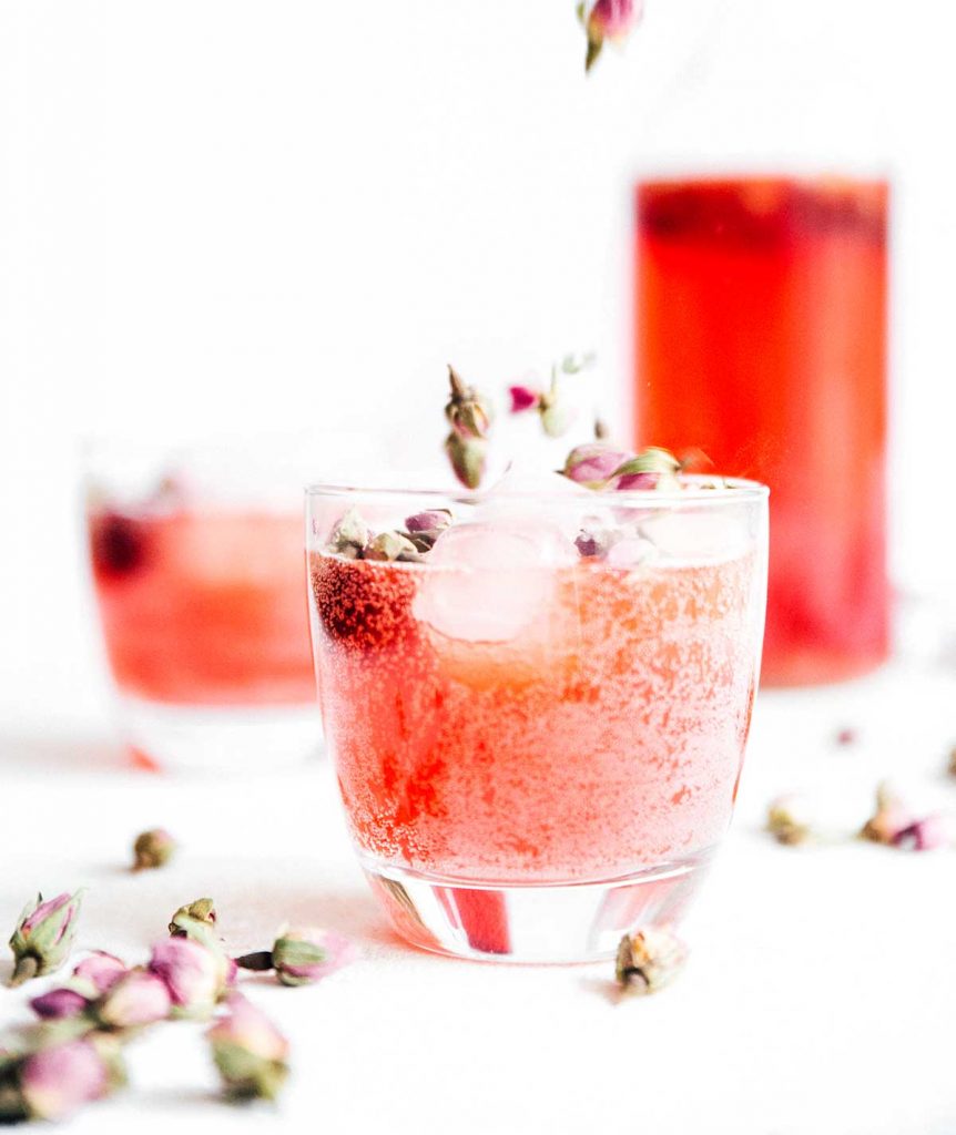 Carbonated rose kombucha in a glass on a white background