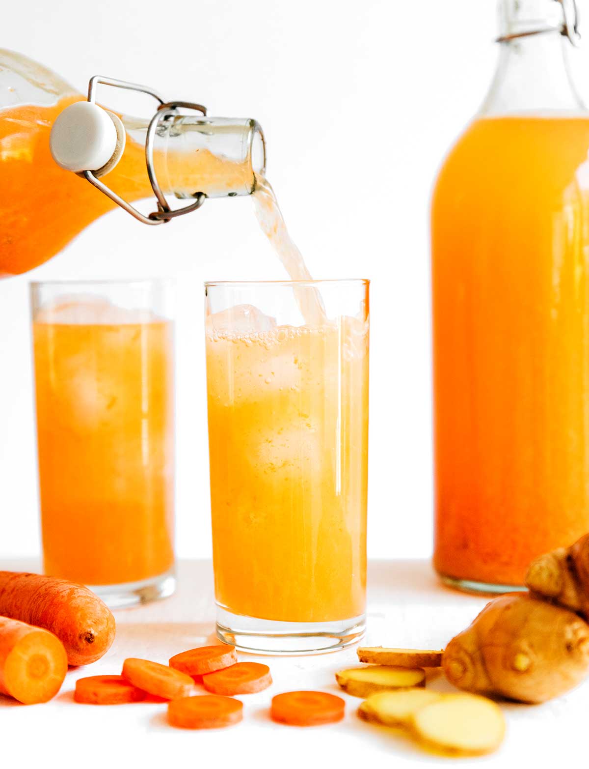 Pouring orange kombucha into a glass