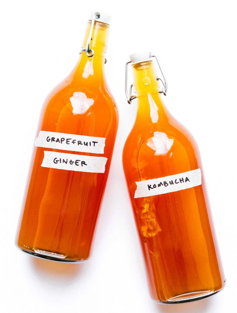 Bottles of grapefruit kombucha on a white background
