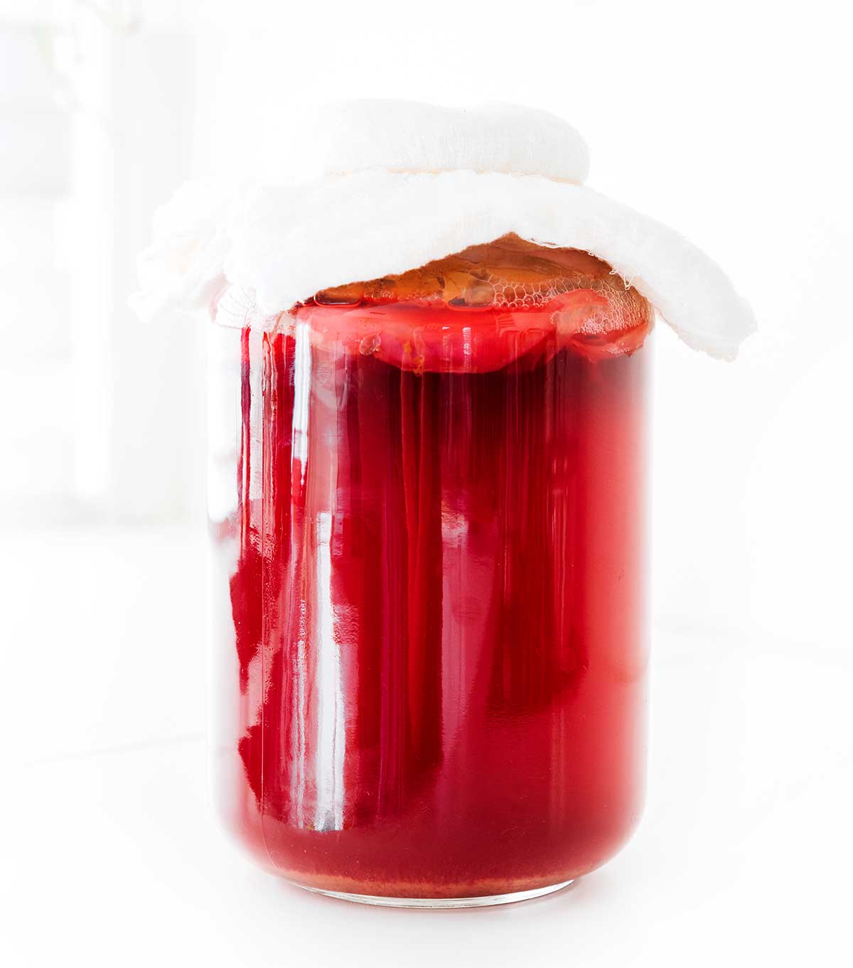 Brewing hibiscus kombucha in fermentation bottles on a white background