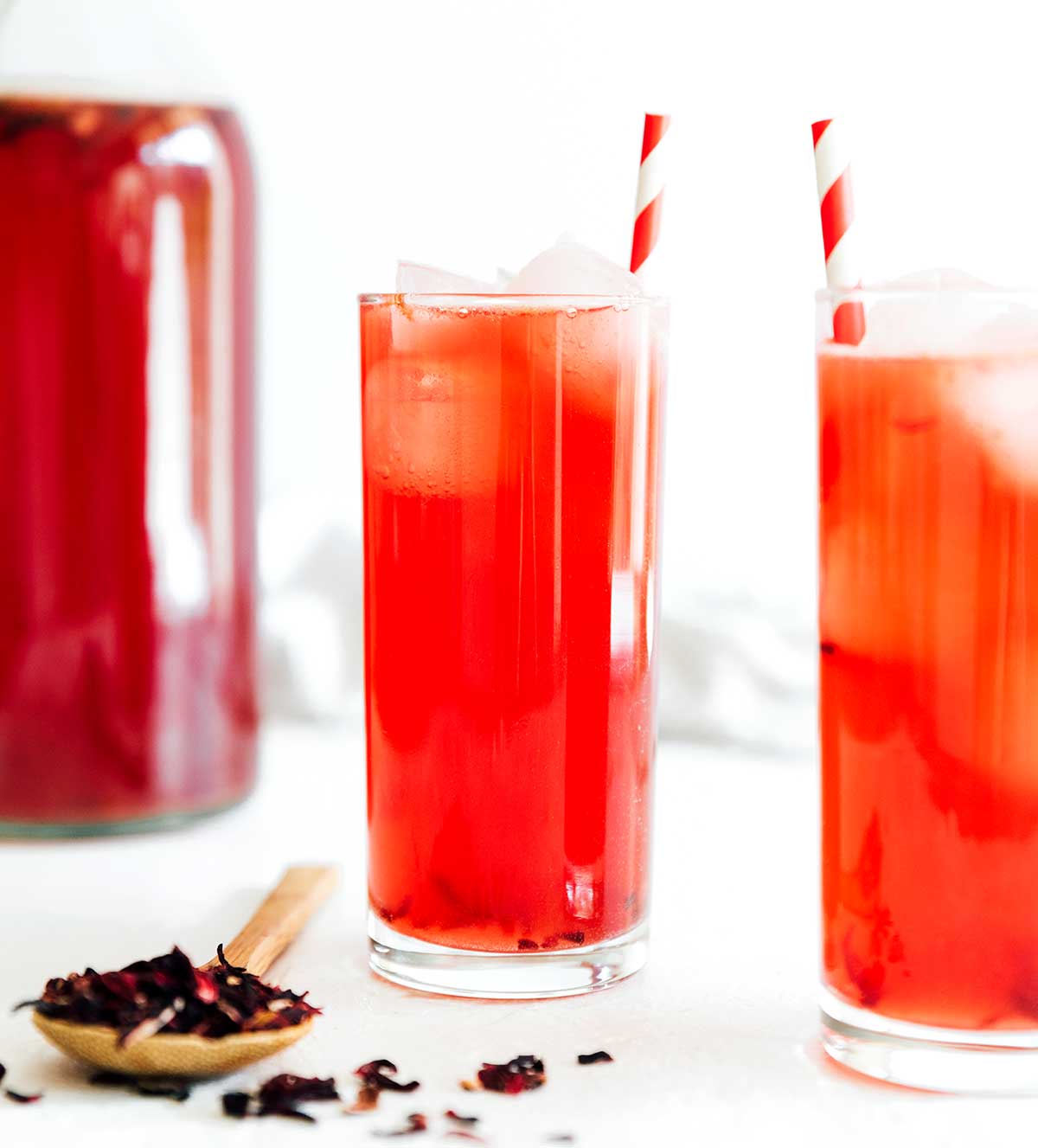 Hibiscus kombucha in a glass with a paper straw