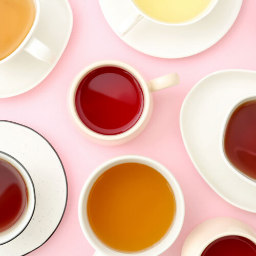 Many types of tea on pink background.