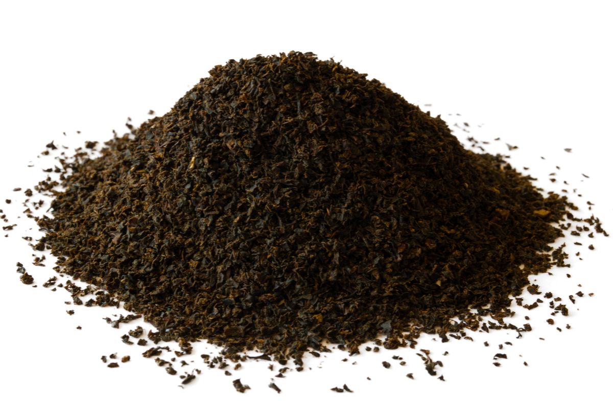 Orange pekoe tea leaves ground on an isolated white background.